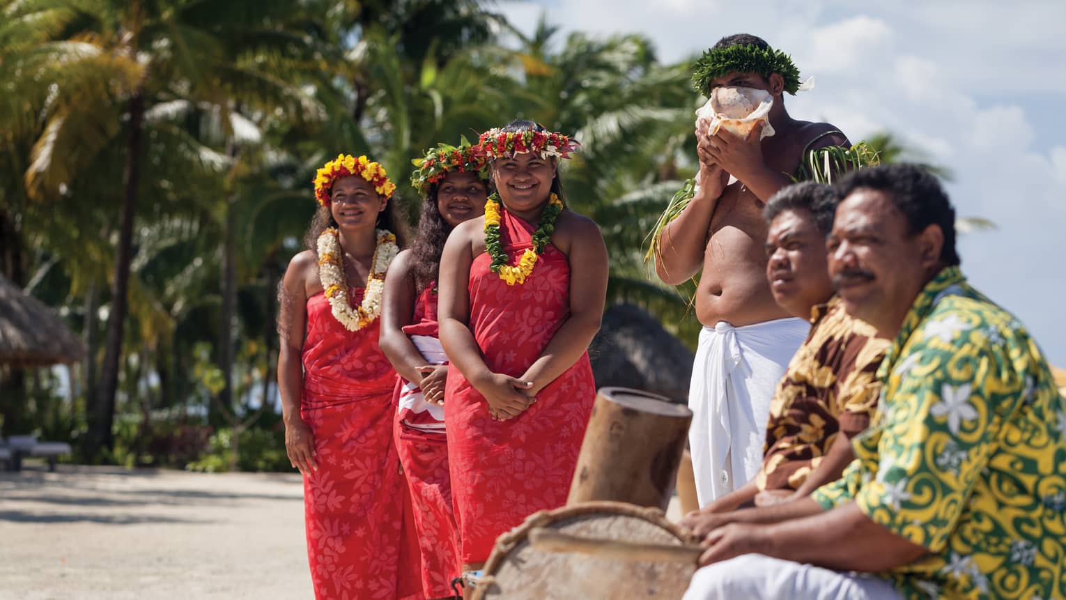 Polynesian wedding ceremony, guests wearing traditional clothing, man with shell