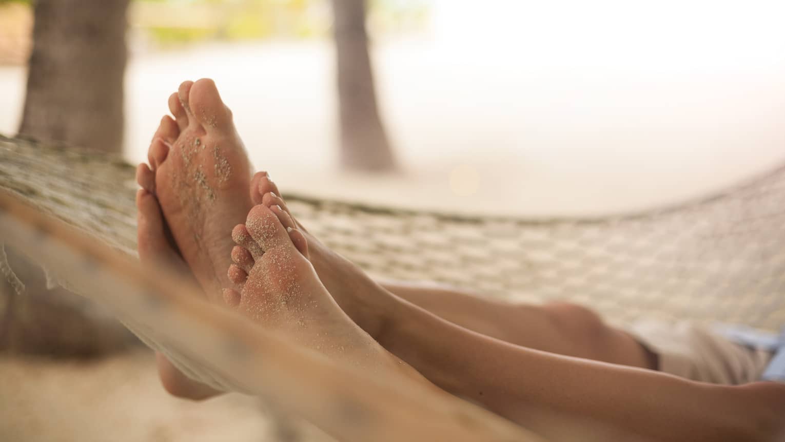 Couple's feet intertwined at end of hammock