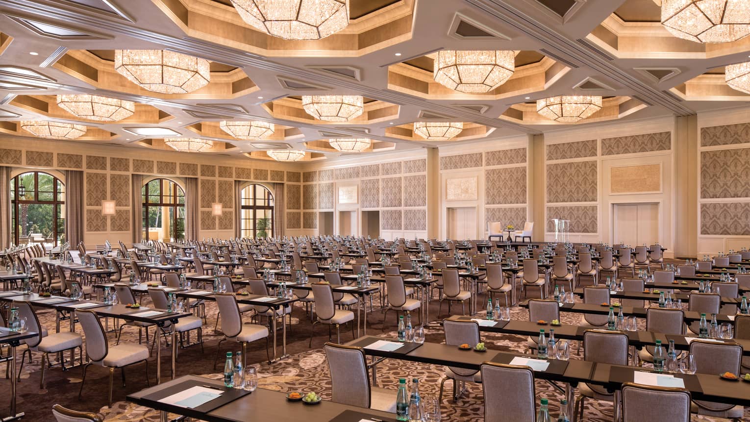 Rows of meeting tables, chairs in large Grand Ballroom under lights 