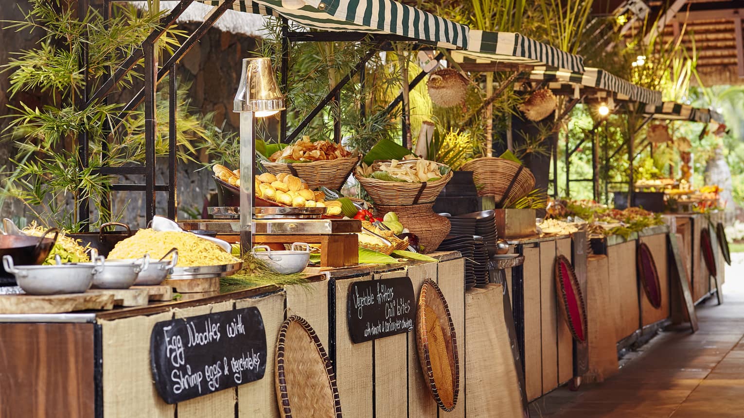 Zilwa Night tropical buffet table with wicker baskets, breads, rice and noodle dishes 