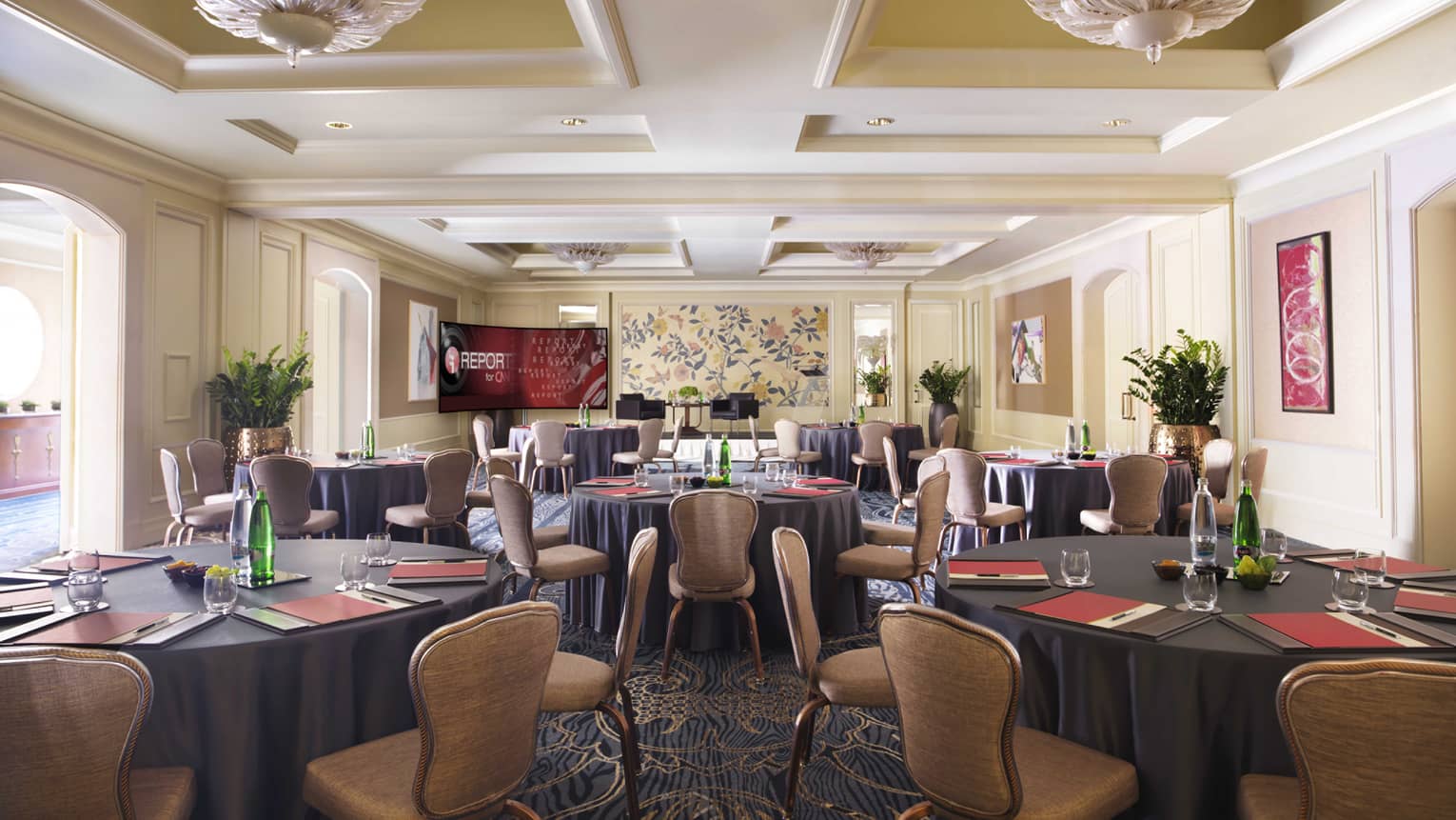 Sunny Karel Meeting Room with round tables lined with tan chairs 
