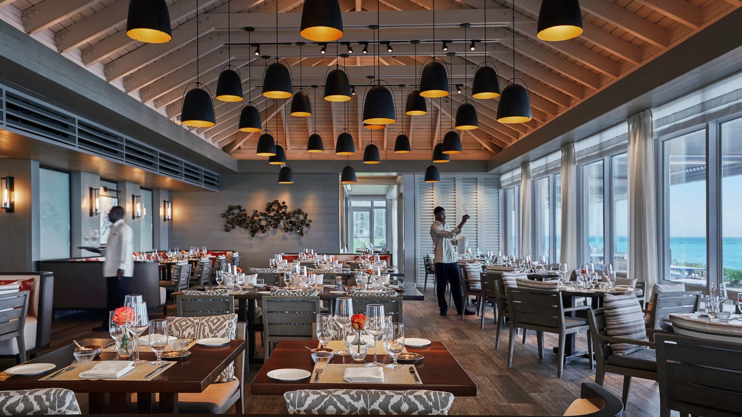 Versailles Terrace staff set dining room under tall ceiling, lamps