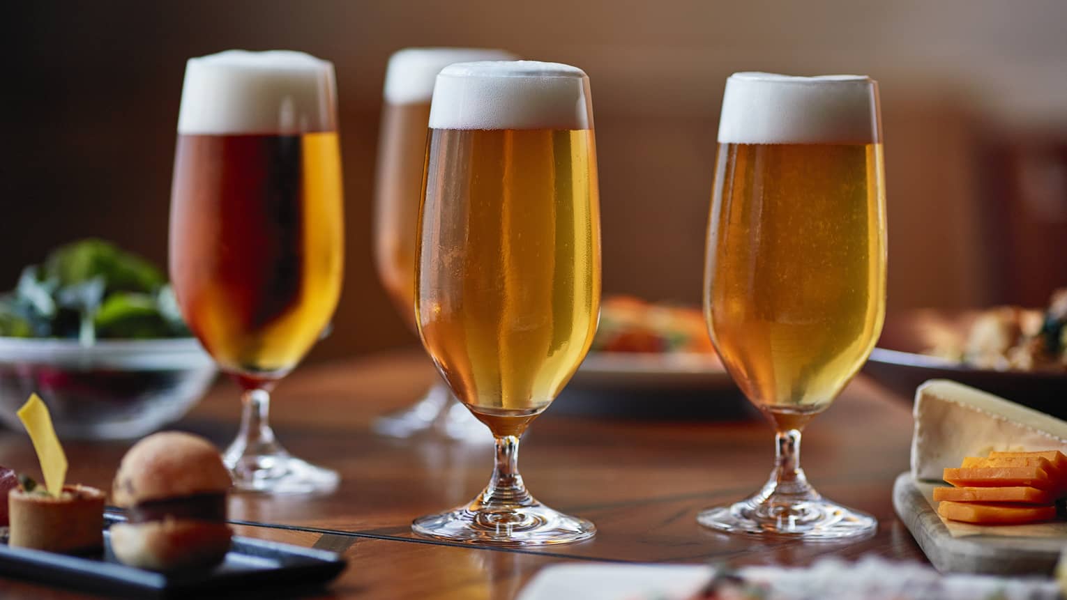 Glasses of beer on table with appetizers