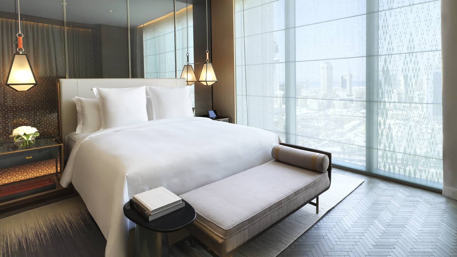 Four Seasons Executive Suite bed in front of mirror wall, hanging lights, beside floor-to-ceiling window