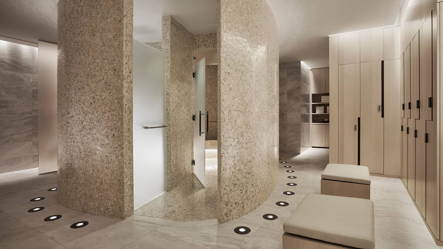 Curved white stone walls in Spa locker room, wood lockers 