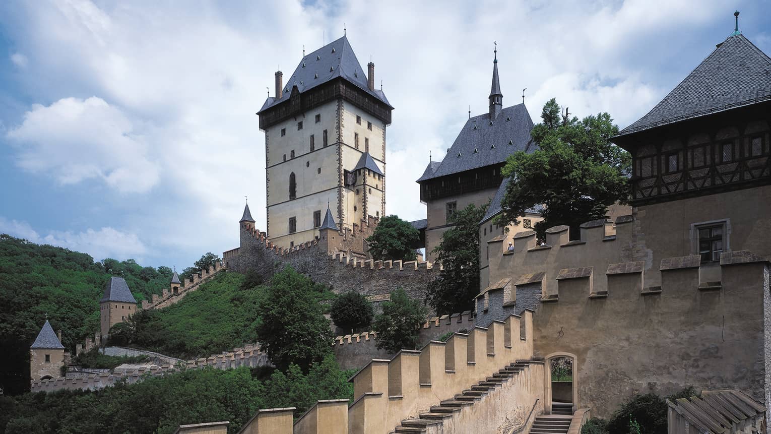 Looking up at historic Prague Karlstejn Castle towers, castle walls on sunny day