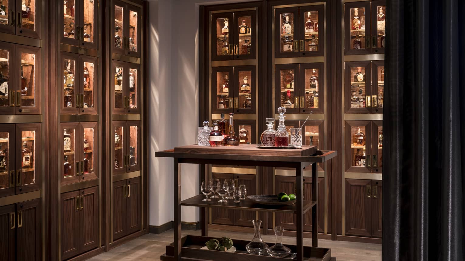 Bourbon cart in room with wood and glass display cases with liquor bottles