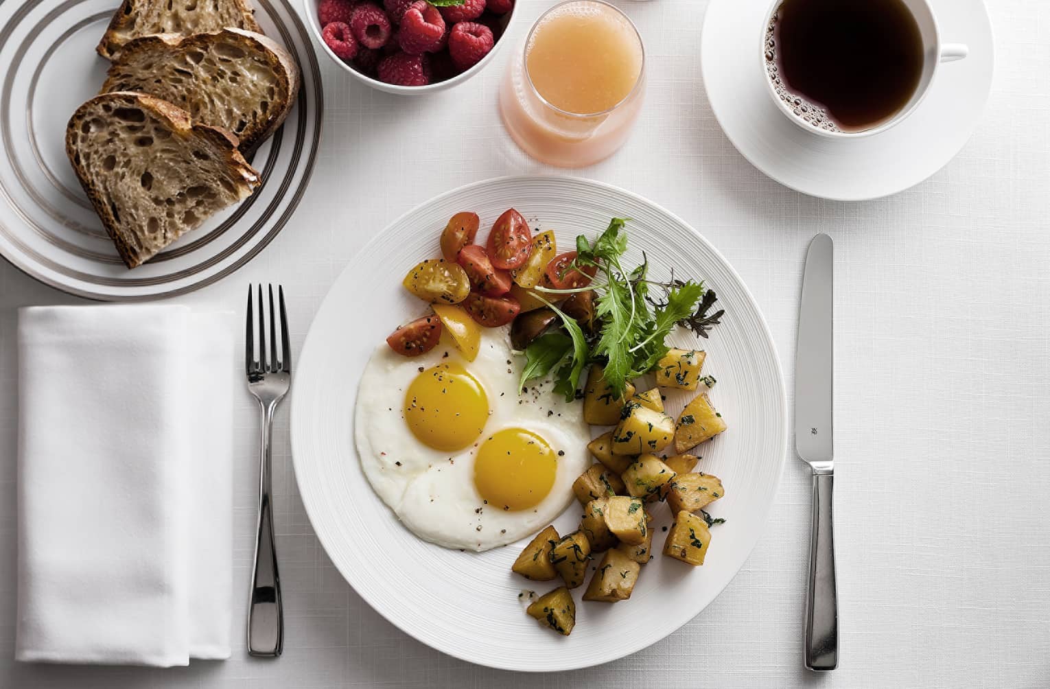In-bungalow dining breakfast with sunny side egg, roast potatoes and salad, toast, coffee and fresh fruit