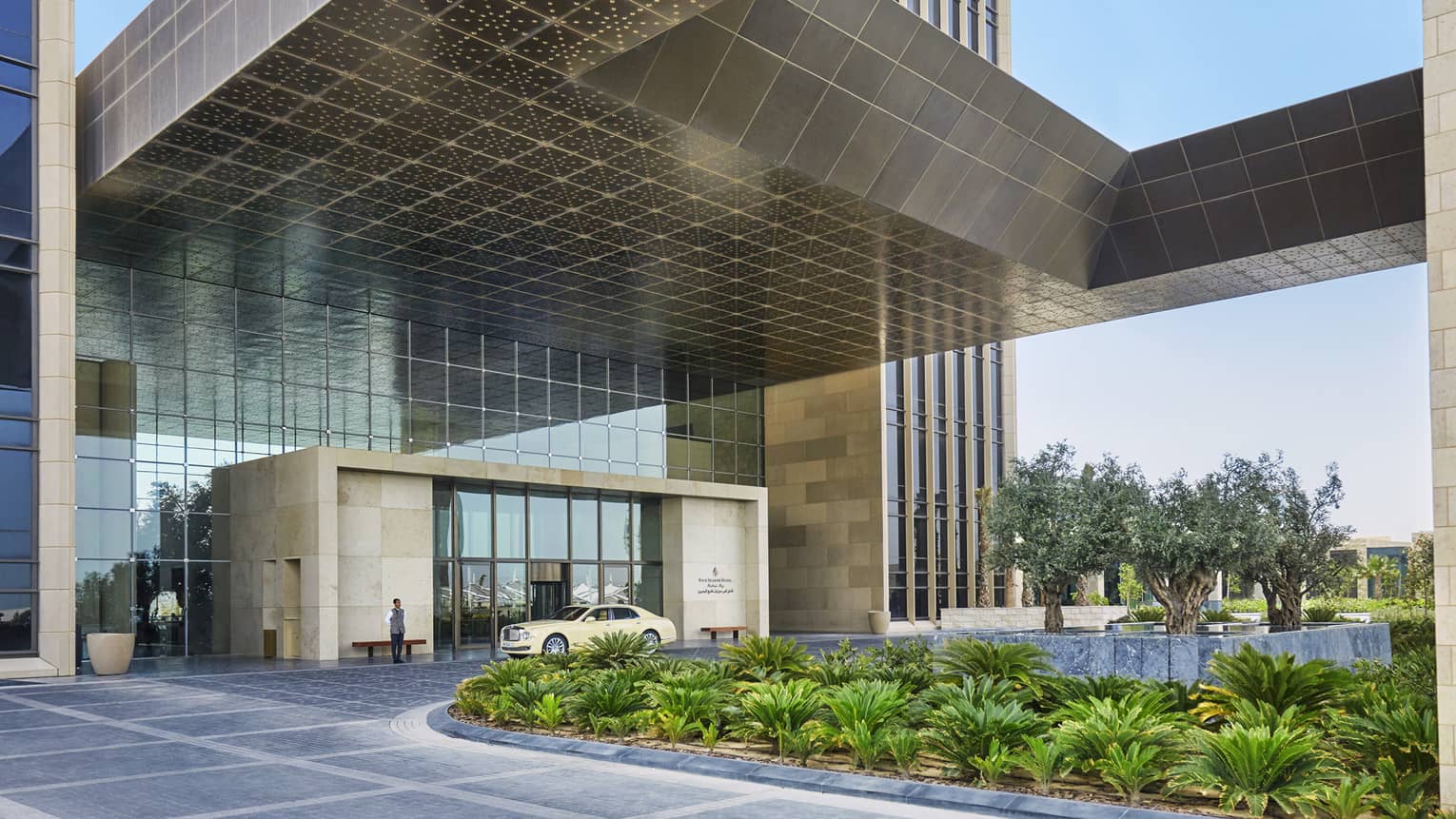 Car parked under modern awning at Four Seasons Hotel Bahrain Bay entrance
