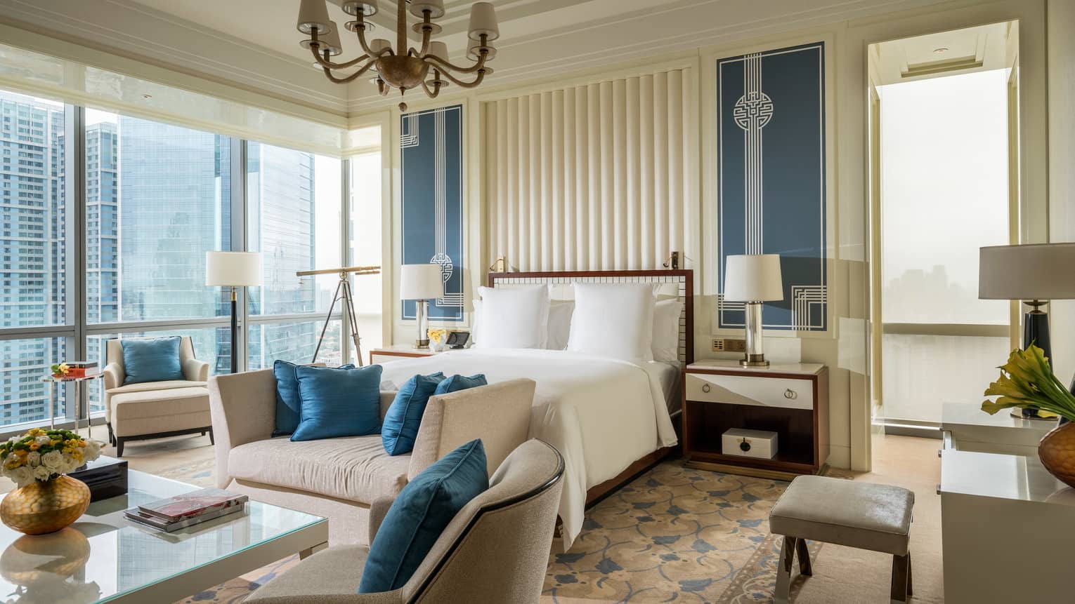 Chairman Suite large bed, plush sofas with blue cushions, corner windows with city views