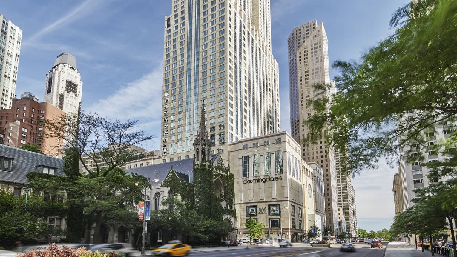 Chicago street exterior on sunny day with Bloomingdales store at base of tall white tower