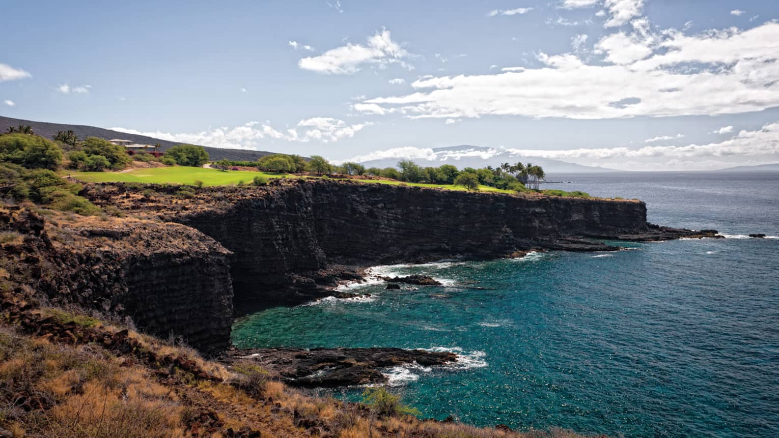 Sweeping view of Manele Golf Course on high cliffs over ocean