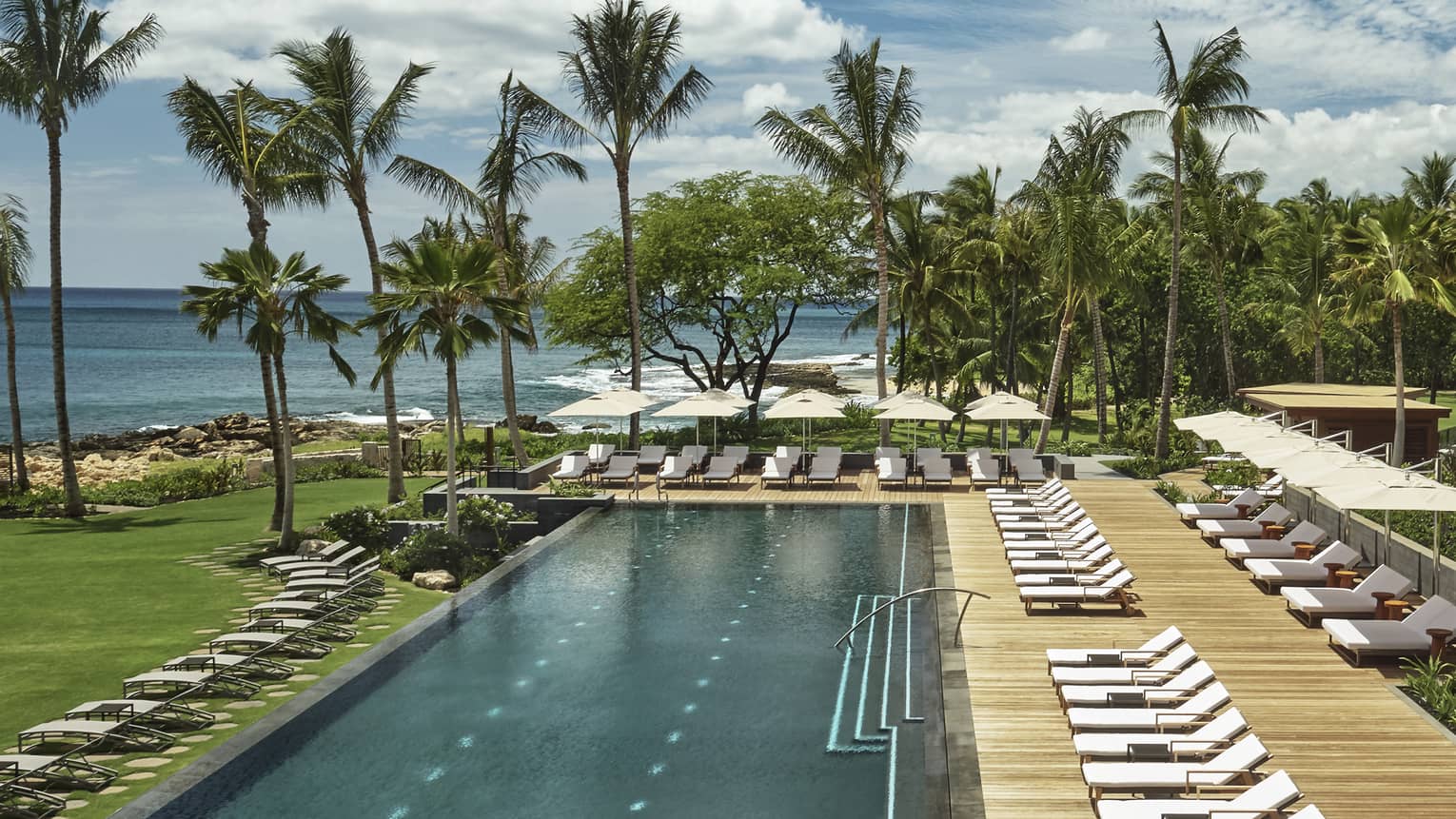 A long adult pool and sun chairs