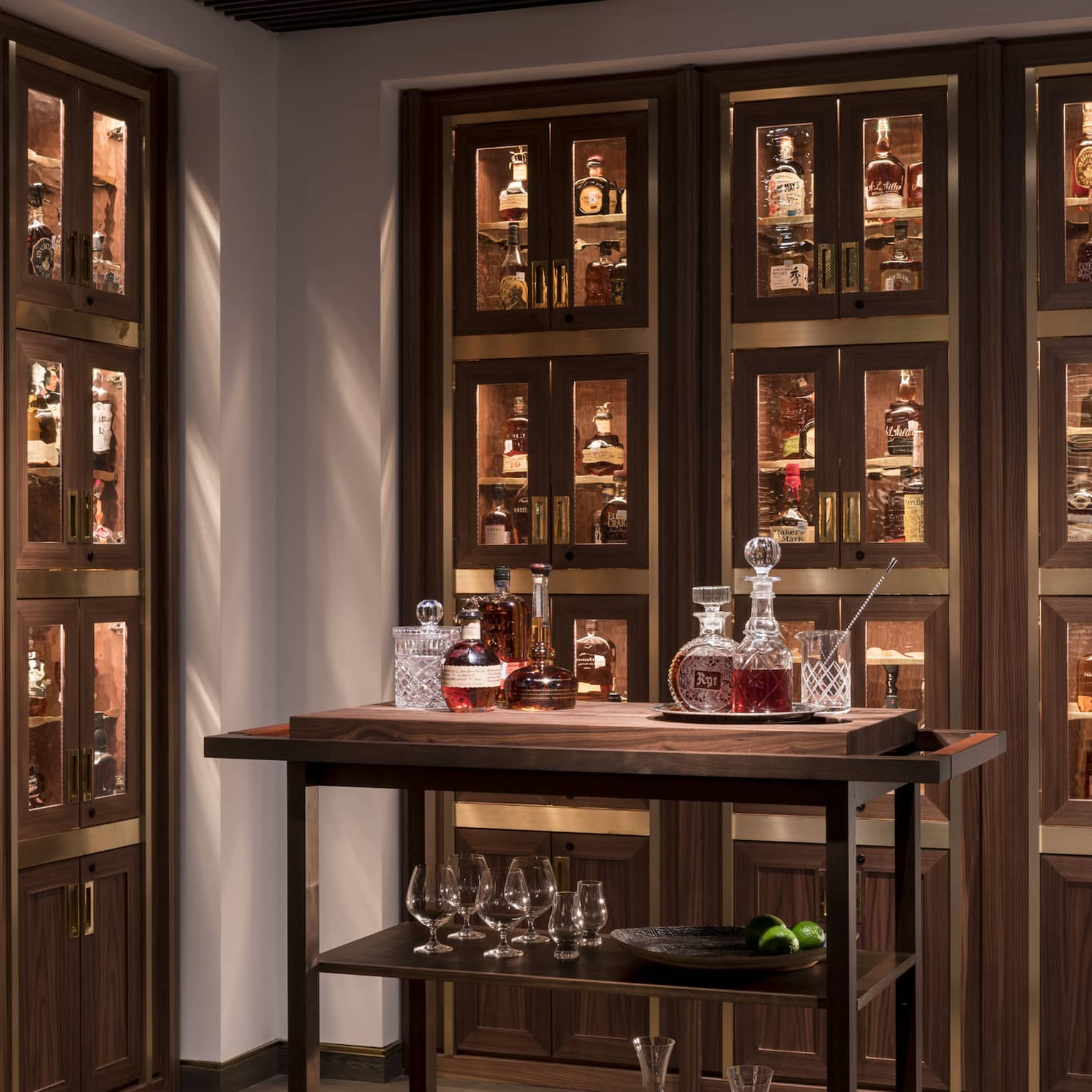 Bourbon cart in room with wood and glass display cases with liquor bottles 