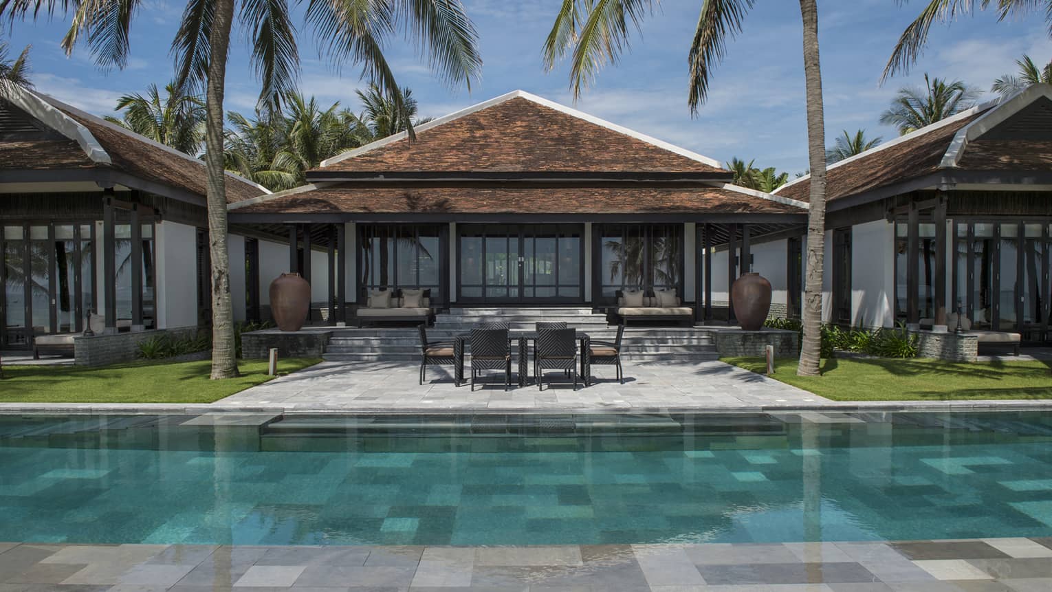 View of Ocean View Pool Villa exterior, patio under palms, from outdoor pool
