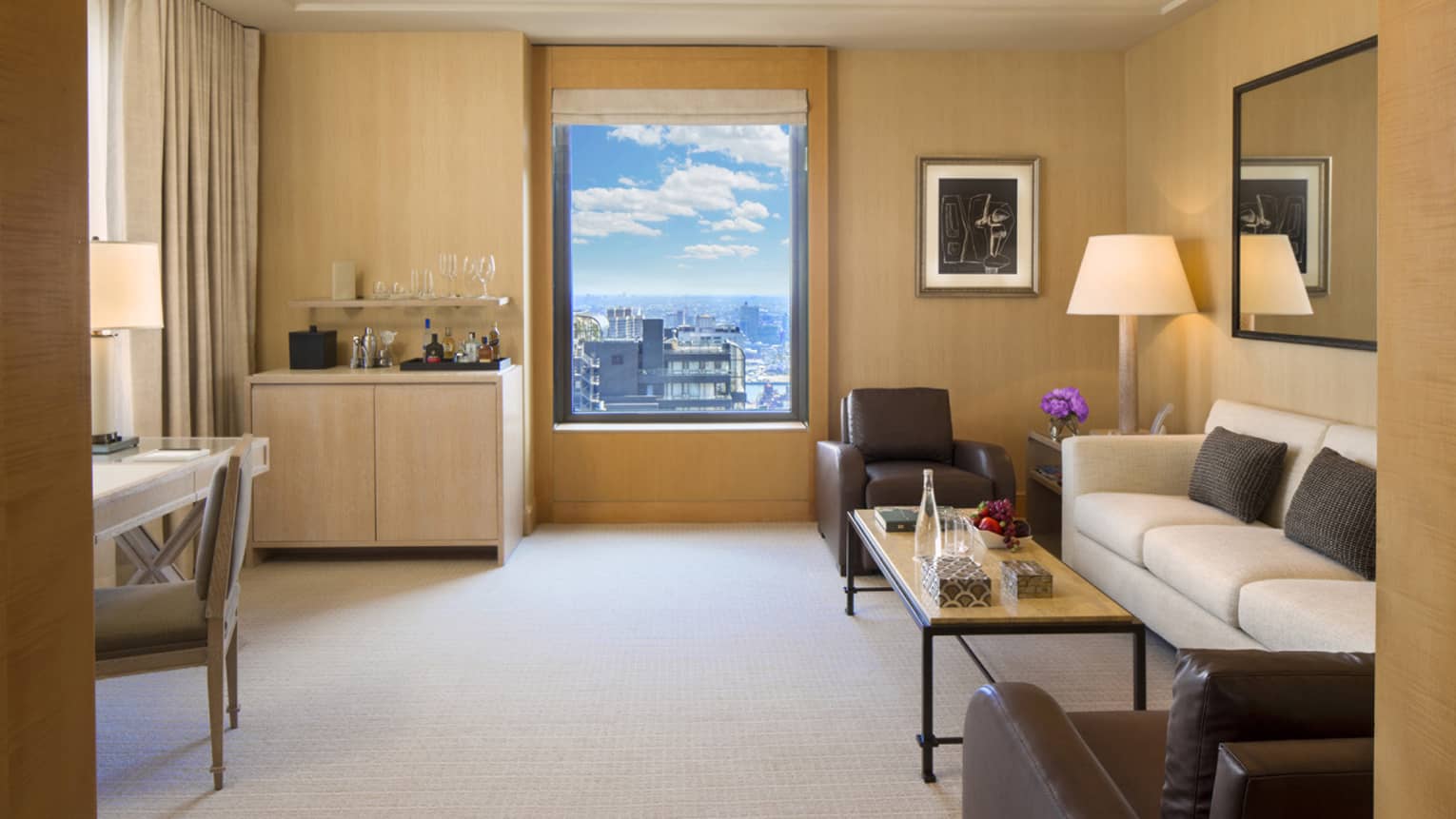 Park Avenue Suite small wet bar by window, white sofa with two brown leather chairs