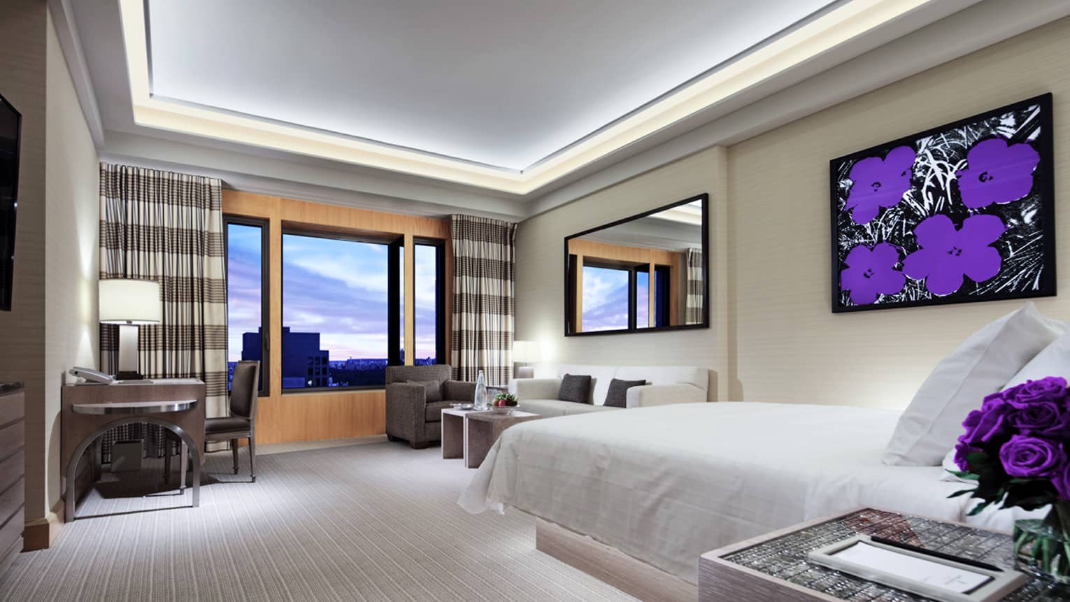 Gotham Junior Suite bed, seating area, desk, modern painting of purple flowers