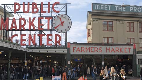 Public Market Center and Farmers Market signs over crowd along sidewalk