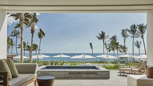 Pacific Suite open to wall to patio with stone plunge pool, lounge chairs, ocean views