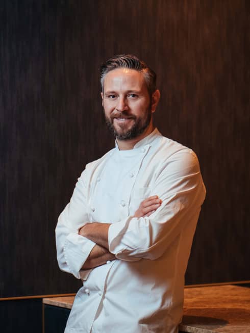 Portrait photo of Mode Kitchen & Bar head chef Francesco Mannelli in chef's uniform