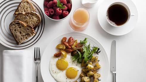 In-bungalow dining breakfast with sunny side egg, roast potatoes and salad, toast, coffee and fresh fruit