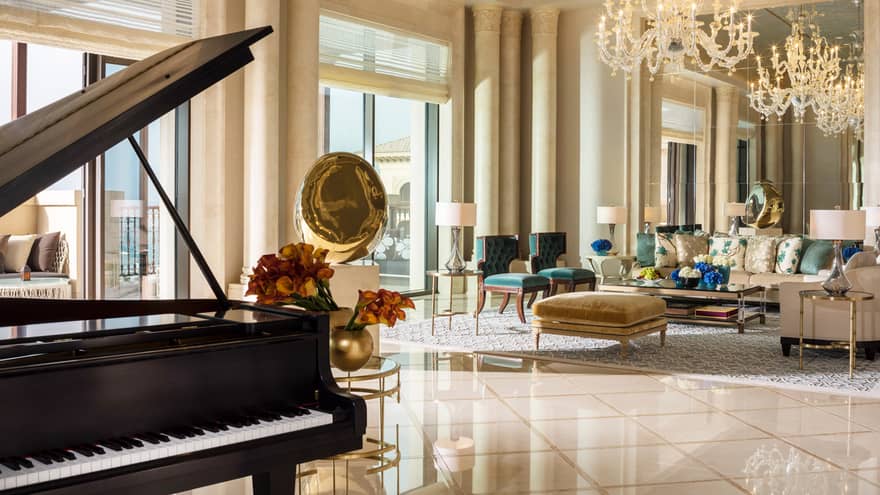 Royal Suite grand piano with elegant living room, crystal chandeliers, gold sculptures