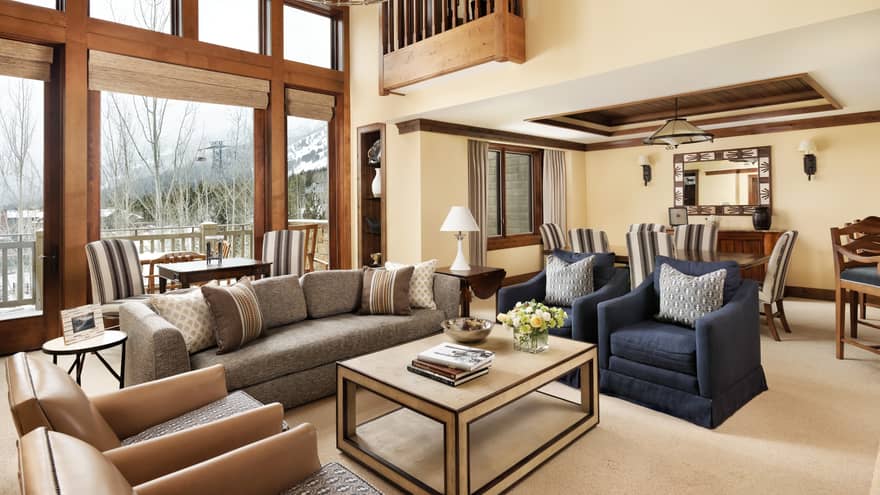 Bright loft-like room with high ceilings, windows over living room sofas