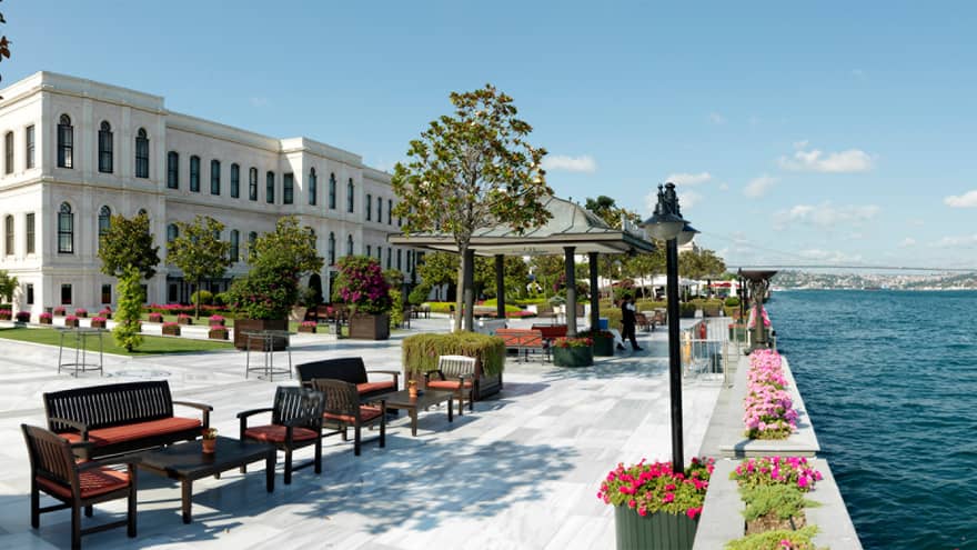 Lounge seating areas on large, sunny hotel outdoor event patio on water 