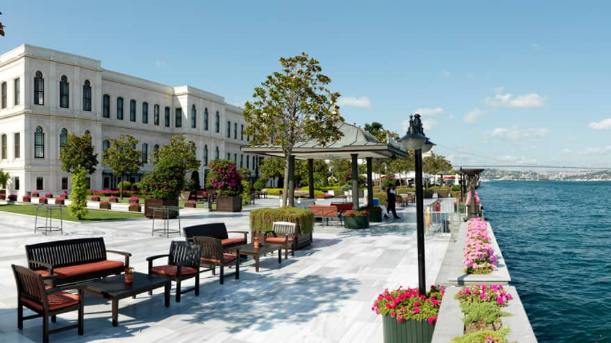 Lounge seating areas on large, sunny hotel outdoor event patio on water 
